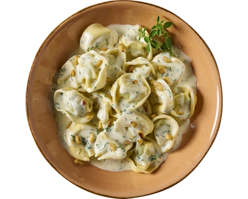 HOFMANNs Tortelloni alla panna in einer Kräuter-Sahnesoße, serviert mit Kräutern und Pinienkernen.