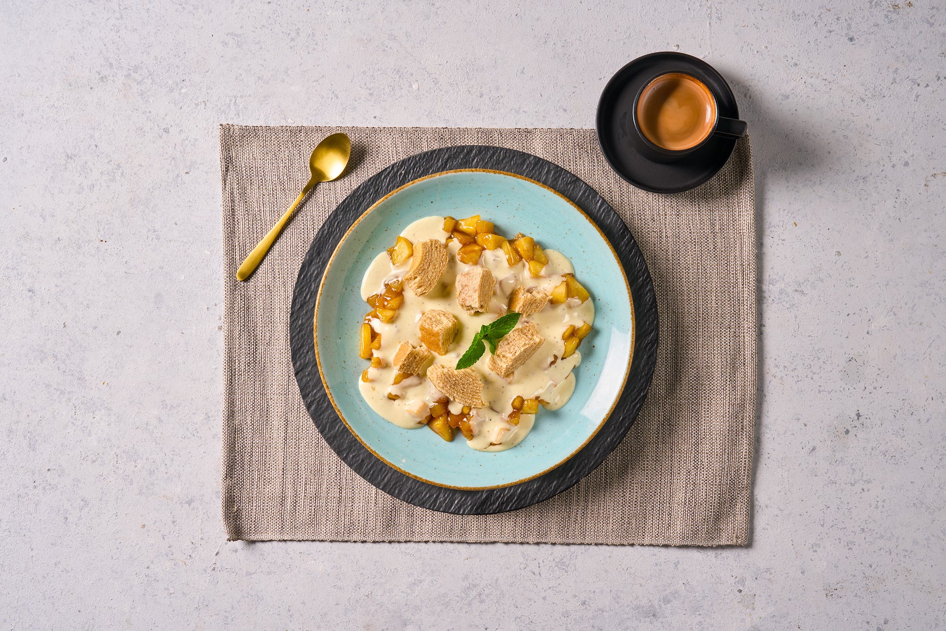 Cremiges Dessert mit Brotwürfeln auf einem blauen Teller - ideal für Ihre Hofmanns Shop Last Chance-Box Wintermomente.