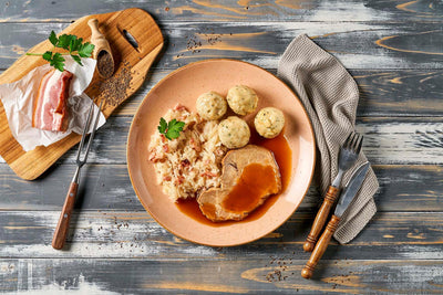 Teller mit Schweinebraten, Knödeln und Sauerkraut – HOFMANNs herzhafte Küche vom Feinsten.