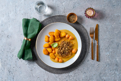 Ein Teller mit Eintopf, Kartoffeln, Tomaten - perfekt für die Last Chance-Box Wintermomente von Hofmanns Shop.