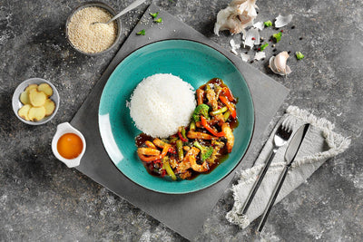 Ein Teller Reis und Gemüse mit Soße, dazu HOFMANNs Asiatische Genussreise Bami Goreng.