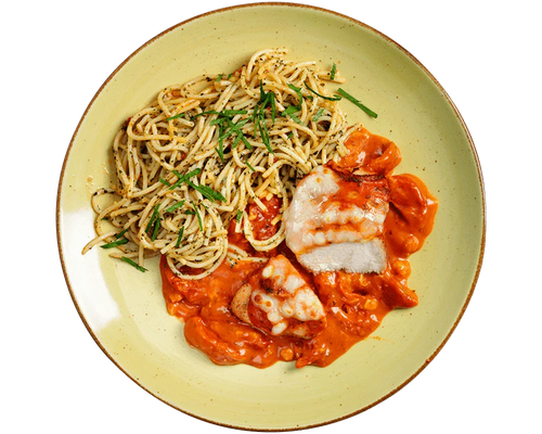 Teller mit mediterranen Kräuter-Spaghetti mit Hofmanns Shop Hähnchenbrust „Caprese“ in Tomatensauce.