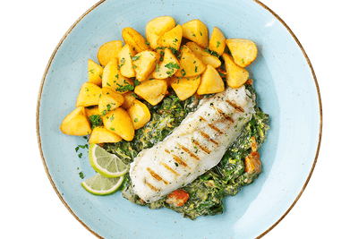 Gegrilltes Alaska-Seelachsfilet von Hofmanns Shop mit Kartoffeln, Gemüse und Limettenscheiben.