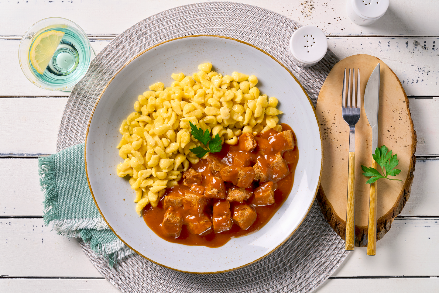 Ein Teller mit gepflanzten Steakhäppchen "Gulasch Style" von Hofmanns Shop mit Eierspätzle und Petersilie.