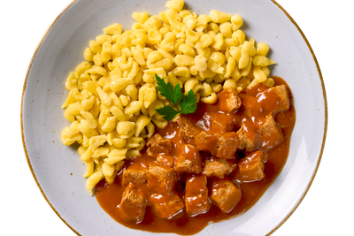 Ein Teller Hofmanns Shop gepflanzt.steak Bites "Gulasch Style" auf Eierspätzle, garniert mit Petersilie.