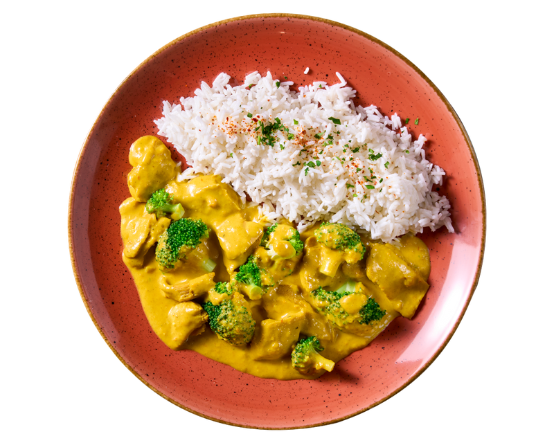 HOFMANNs „planted.chicken“ »Butter Chicken Style« mit weißem Reis, serviert auf einem orangefarbenen Teller.