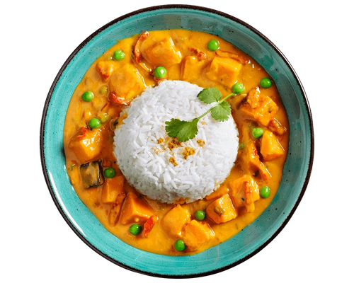 Eine Schüssel HOFMANNs Süßkartoffel-Curry mit Tofu, Erbsen und Basmatireis, garniert mit Koriander.
