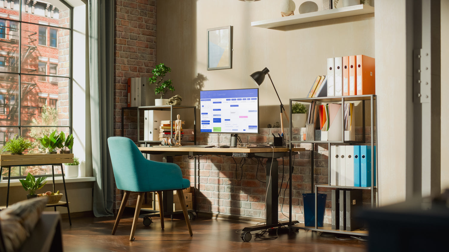 Gemütliches Heimbüro mit Schreibtisch, Computer, blaugrünem Stuhl, Regalen und einem großen Fenster mit Tageslicht.