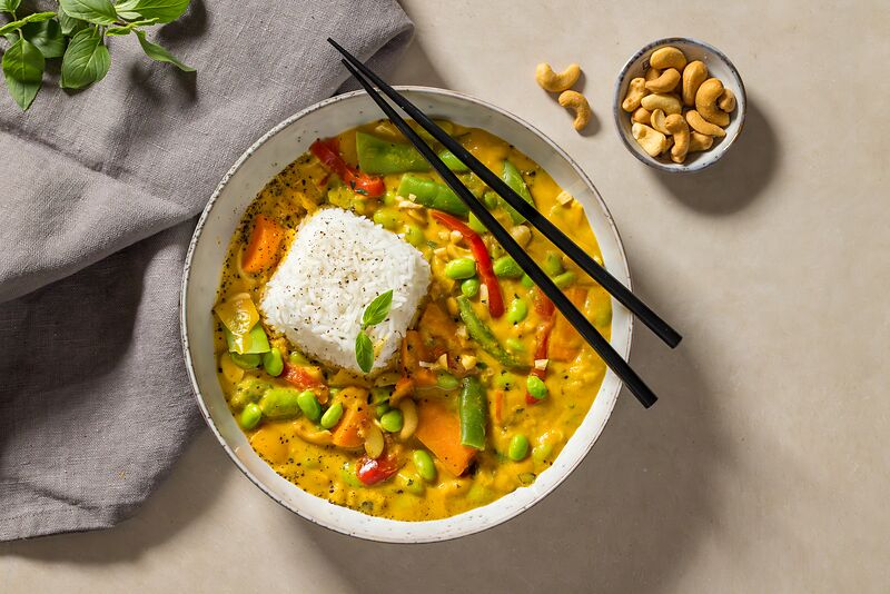 HOFMANNs Hello Summer Box: gelbes Curry mit Reis, Gemüse, Stäbchen und Cashews.