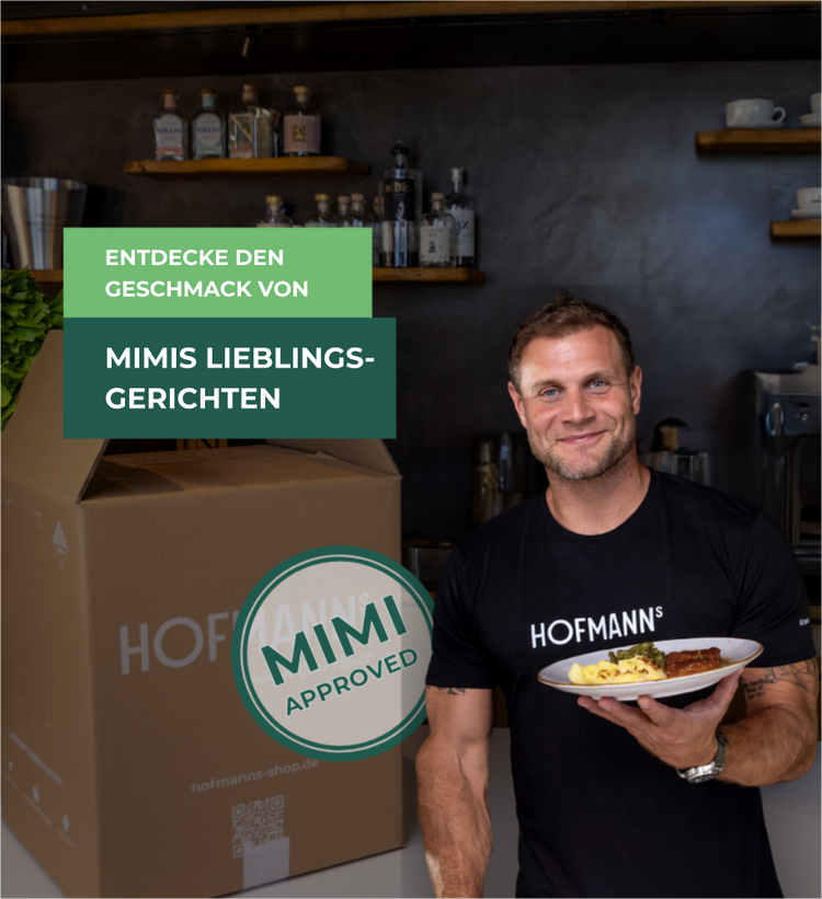 Mann hält in einer Küche einen Teller mit Essen neben einer großen Kiste; Text wirbt für ein exklusives Angebot einer Essensbox.