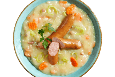 Eine Schüssel Hofmanns Shop Kartoffelsuppe „Norddeutsche Art“ mit Karotten, Wurst, Lauch und Petersilie.