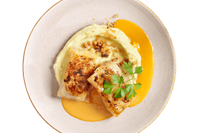 Zwei Kohlrouladen von Hofmanns Shop auf Kartoffelpüree mit Orangensauce und Petersilie.