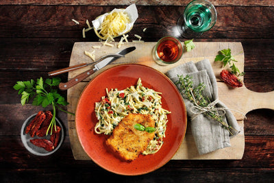 Genießen Sie Pasta mit Sauce und HOFMANNs Schnitzel-Box, serviert in Restaurantqualität.