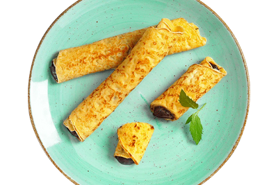 Three Hofmanns Shop Nougat-Palatschinken auf grünem Teller mit Minze – Leckeres Fertiggericht.