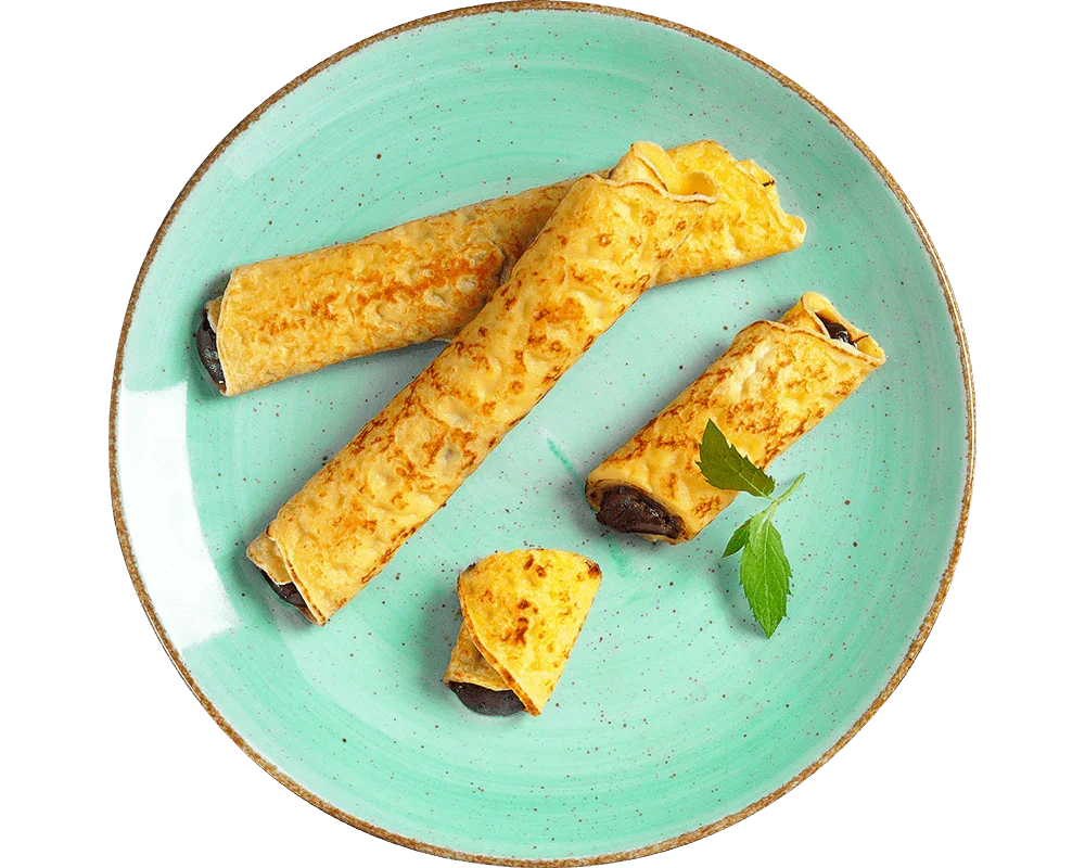 Three Hofmanns Shop Nougat-Palatschinken auf grünem Teller mit Minze – Leckeres Fertiggericht.