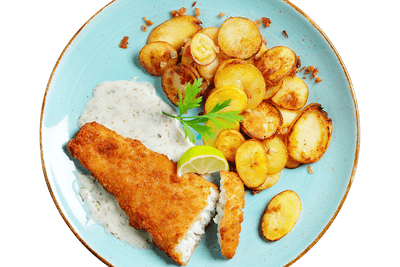 Kabeljaufilet „Kräuter & Speck“ von Hofmanns Shop mit Bratkartoffeln und Kräuter-Sahne-Dip auf blauem Teller.