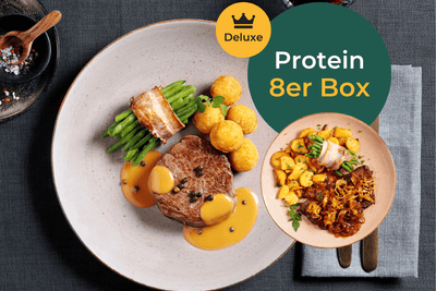 Ein Steak mit Sauce, grünen Bohnen und Kartoffeln neben der „Protein Deluxe-Box“ von HOFMANNs.