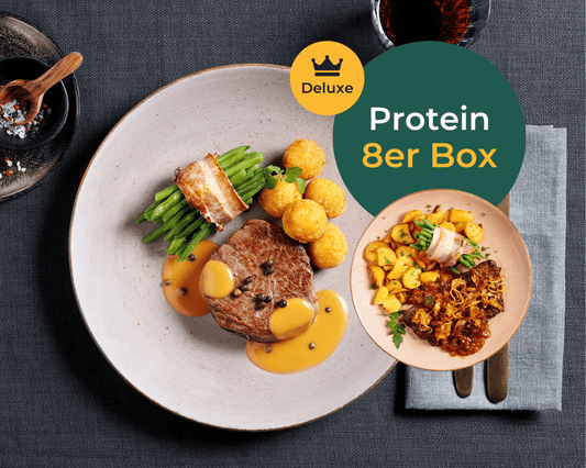 Ein Steak mit Sauce, grünen Bohnen und Kartoffeln neben der „Protein Deluxe-Box“ von HOFMANNs.