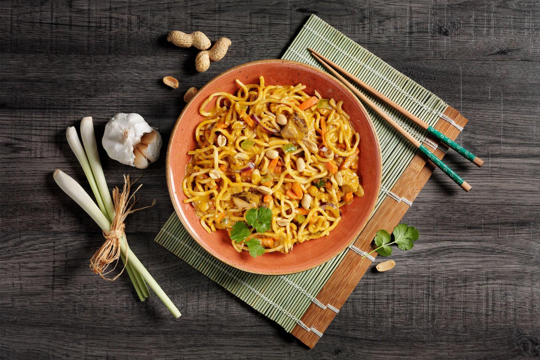 Eine Schüssel mit Vegan-Box gebratenen Nudeln mit Gemüse von HOFMANNs, voller Vielfalt auf den Teller.