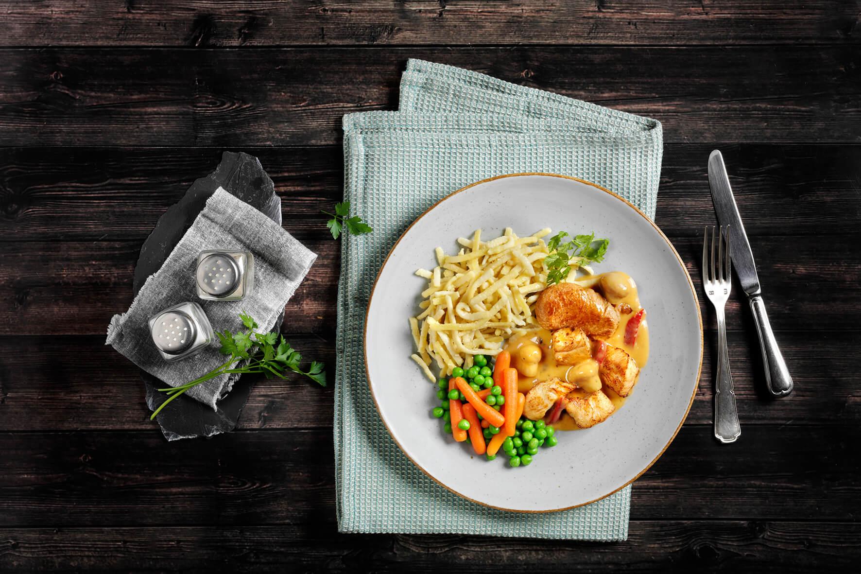 Genießen Sie HOFMANNs Geflügel-Box: Hähnchen, Spätzle, Erbsen, Karotten & Zwiebeln in Restaurantqualität.