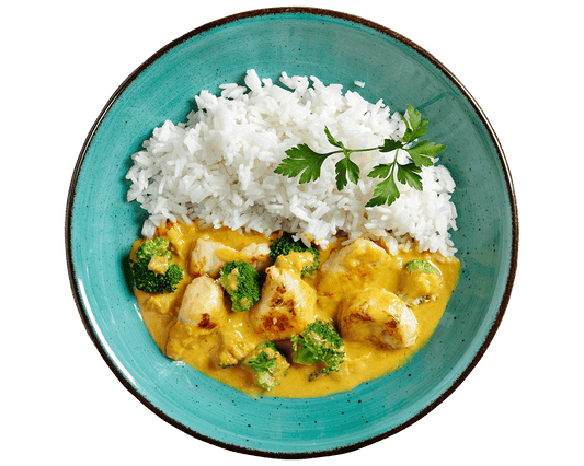 Ein türkisfarbener Teller mit Hofmanns Shop Gelbes Curry „Butter Chicken Style“, Basmatireis und Brokkoli.