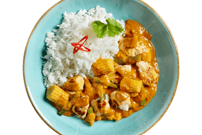 Hähnchen Erdnuss-Tikka von Hofmanns Shop mit Curry, Babymais und Koriander auf blauem Teller.