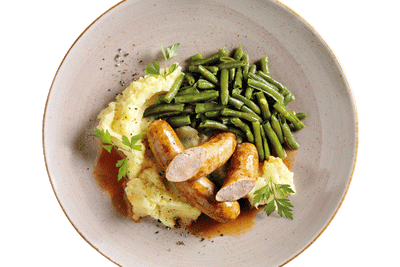 Hofmanns Shop Hausmacher Bratwurst mit Bratensoße, Kartoffelpüree und grünen Bohnen – frisch serviert.