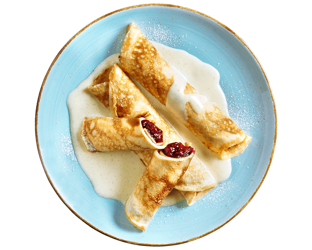 Hofmanns Shop Kirsch-Pfannkuchen mit Vanillesoße und Sauerkirschen, mit Zucker bestäubt auf einem blauen Teller.