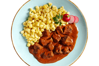 Hofmanns Shop Rindsgulasch serviert mit gelben Knödeln, Petersilie und Radieschenscheiben.