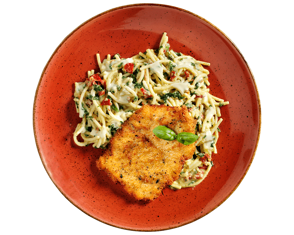 Hofmanns Shop Schnitzel à la Carbonara mit Spinat-Spaghetti, serviert auf einem roten Teller mit Basilikum.