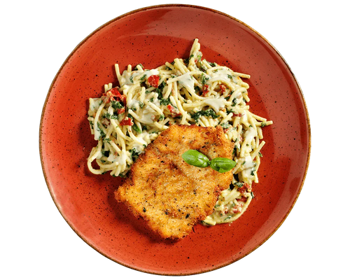 Hofmanns Shop Schnitzel à la Carbonara mit Spinat-Spaghetti, serviert auf einem roten Teller mit Basilikum.