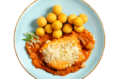 Ein Teller Hofmanns Shop Schweineschnitzel „Mailänder Art“ mit Kartoffelbällchen und Hähnchen-Parmigiana.