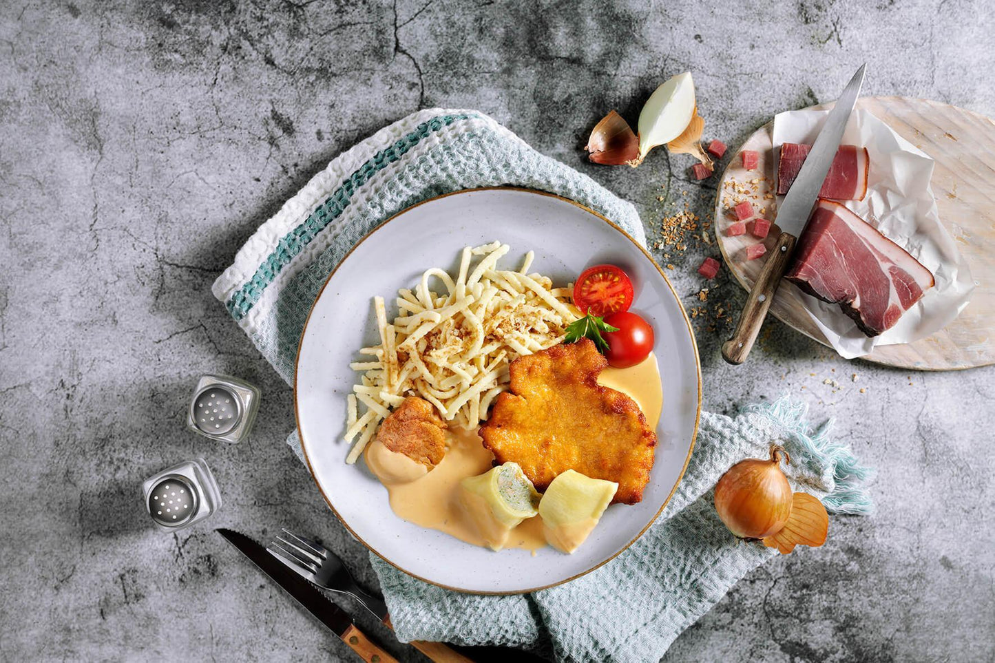 Hausmannskost-Box von HOFMANNs: Teller mit Schnitzel, Pommes, Soße, Tomate; Rinderrouladenseite.