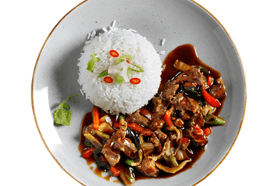 Ein Teller Teriyaki-Rinde von Hofmanns Shop mit Reis, gebratenem Gemüse, Chili und Kräutern.