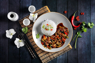 Teriyaki-Rind von Hofmanns Shop mit Wok-Gemüse, inspiriert von japanischer Küche, mit Stäbchen.