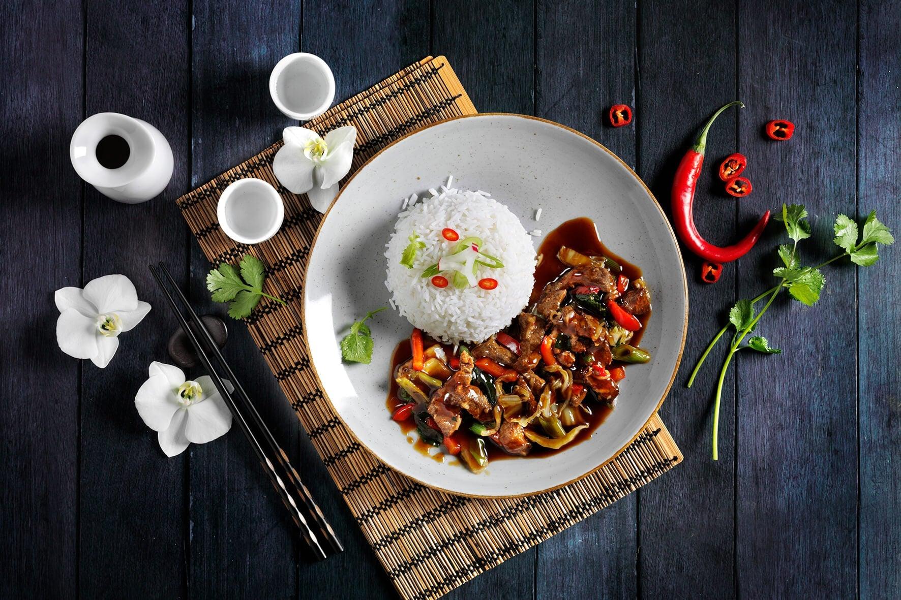 Teriyaki-Rind von Hofmanns Shop mit Wok-Gemüse, inspiriert von japanischer Küche, mit Stäbchen.