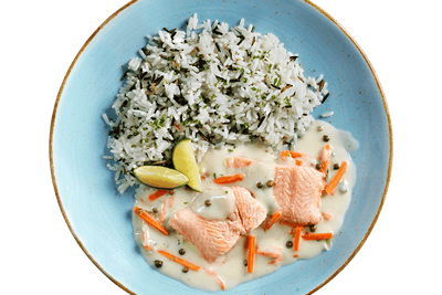 Ein blauer Teller mit Reis, Hofmanns Shop Wildlachs - Grüne Paprika, Karottenstreifen & zwei Limettenspalten.
