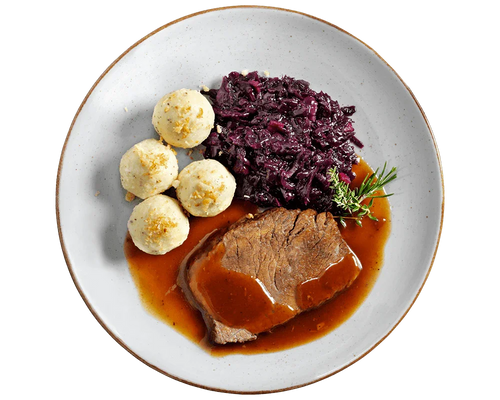 Zarter Sauerbraten von Hofmanns Shop mit Bratensoße, Apfelrotkohl und 3 Kartoffelklöße auf einem Teller.